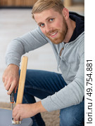 handsome young working man repairing wooden stool using screwdriver. Стоковое фото, агентство Ingram Publishing / Фотобанк Лори