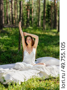 Woman sleeps on a mattress in the summer forest. Girl wakes up in a summer forest. Стоковое фото, агентство Ingram Publishing / Фотобанк Лори