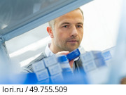 tidying goods in cardboard box in a warehouse. Стоковое фото, агентство Ingram Publishing / Фотобанк Лори