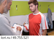 coach advising football player in changing room before the match. Стоковое фото, агентство Ingram Publishing / Фотобанк Лори