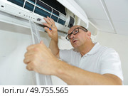 Man working on indoor air conditioning unit. Стоковое фото, агентство Ingram Publishing / Фотобанк Лори