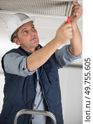 professional man working on ceiling vent with a screwdriver. Стоковое фото, агентство Ingram Publishing / Фотобанк Лори