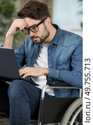 young man in wheelchair concentrating on laptop. Стоковое фото, агентство Ingram Publishing / Фотобанк Лори