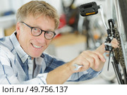 a mature man is fixing a pedal. Стоковое фото, агентство Ingram Publishing / Фотобанк Лори