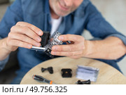 man assembling and testing his new action prtable camera. Стоковое фото, агентство Ingram Publishing / Фотобанк Лори