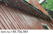 Raindrops are dripping from the eaves of the roof. Shooting at an angle. Стоковое видео, видеограф Ярославский Максим / Фотобанк Лори