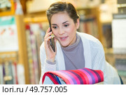 woman using the phone in a textile store. Стоковое фото, агентство Ingram Publishing / Фотобанк Лори