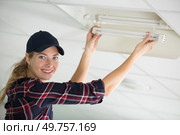 a woman changing light bulb. Стоковое фото, агентство Ingram Publishing / Фотобанк Лори
