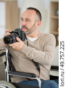 male disabled photographer holds camera in his hands. Стоковое фото, агентство Ingram Publishing / Фотобанк Лори