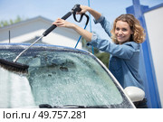 woman usingspray gun to remove the soap. Стоковое фото, агентство Ingram Publishing / Фотобанк Лори