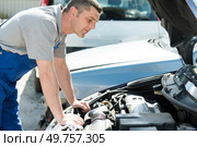 mechanic with scan tool diagnosing car in open hood. Стоковое фото, агентство Ingram Publishing / Фотобанк Лори