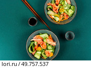 Fresh Asian salad with smoked salmon, fresh cucumber and chopstick. Top view.. Fish salad with raw cucumber. Стоковое фото, агентство Ingram Publishing / Фотобанк Лори