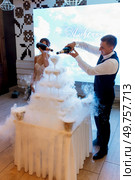 newlyweds at a banquet pour champagne into a pile of glasses for guests. Стоковое фото, агентство Ingram Publishing / Фотобанк Лори