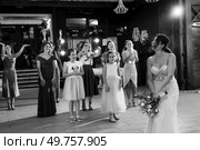 bride in a white dress throws a wedding bouquet to her unmarried girlfriends. Стоковое фото, агентство Ingram Publishing / Фотобанк Лори