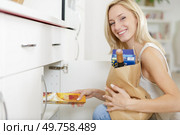 young lady putting away provisions in the kitchen. Стоковое фото, агентство Ingram Publishing / Фотобанк Лори