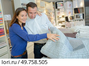 a couple checking a bedspread. Стоковое фото, агентство Ingram Publishing / Фотобанк Лори