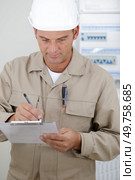 portrait of electrician standing next to fuseboard. Стоковое фото, агентство Ingram Publishing / Фотобанк Лори