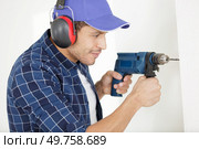 builder worker with drill making hole in wall. Стоковое фото, агентство Ingram Publishing / Фотобанк Лори