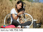 biking cyclist woman using mobile phone texting during workout break. Стоковое фото, агентство Ingram Publishing / Фотобанк Лори