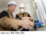 spprentice wearing mask using sander supervisor giving advice. Стоковое фото, агентство Ingram Publishing / Фотобанк Лори