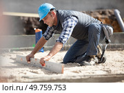 builder leveling floor at site. Стоковое фото, агентство Ingram Publishing / Фотобанк Лори