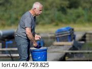 hatchery worker netting kokanee salmon. Стоковое фото, агентство Ingram Publishing / Фотобанк Лори