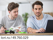 two men are getting online help to assemble a drone. Стоковое фото, агентство Ingram Publishing / Фотобанк Лори