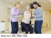 pregnant woman being helping into a wheelchair. Стоковое фото, агентство Ingram Publishing / Фотобанк Лори