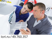 young technician apprentice repairing ac with teacher. Стоковое фото, агентство Ingram Publishing / Фотобанк Лори
