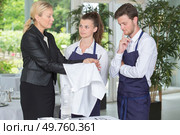 hotel manager showing trainees how to polish cutlery. Стоковое фото, агентство Ingram Publishing / Фотобанк Лори