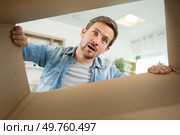 surprised man unpacking a box. Стоковое фото, агентство Ingram Publishing / Фотобанк Лори