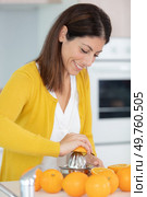 beautiful young woman juicing oranges. Стоковое фото, агентство Ingram Publishing / Фотобанк Лори