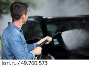 man washing his car under high pressure water outdoors. Стоковое фото, агентство Ingram Publishing / Фотобанк Лори