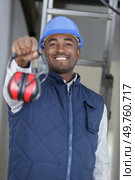 male working proffering ear defenders. Стоковое фото, агентство Ingram Publishing / Фотобанк Лори