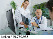 senior doctor showing x-ray to patient in his office. Стоковое фото, агентство Ingram Publishing / Фотобанк Лори