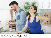 pregnant wife with back ache and husband in the kitchen. Стоковое фото, агентство Ingram Publishing / Фотобанк Лори