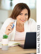 beautiful brunette smoking electronic cigarette and working on her laptop. Стоковое фото, агентство Ingram Publishing / Фотобанк Лори