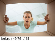 low angle view of disgruntled woman looking into cardboard box. Стоковое фото, агентство Ingram Publishing / Фотобанк Лори