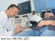 doctor with male patient undergoing arm echography. Стоковое фото, агентство Ingram Publishing / Фотобанк Лори