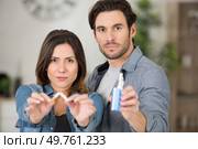 man and woman holding broken cigarette and vaping machine. Стоковое фото, агентство Ingram Publishing / Фотобанк Лори