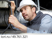 an electrician connecting power cable. Стоковое фото, агентство Ingram Publishing / Фотобанк Лори