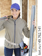 a woman builder carrying metal. Стоковое фото, агентство Ingram Publishing / Фотобанк Лори