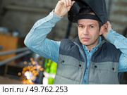 welder putting his visor on. Стоковое фото, агентство Ingram Publishing / Фотобанк Лори