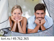 portrait of attractive young couple looking out from tent door. Стоковое фото, агентство Ingram Publishing / Фотобанк Лори