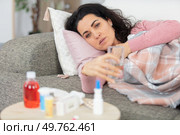 woman ill on sofa with various medication. Стоковое фото, агентство Ingram Publishing / Фотобанк Лори
