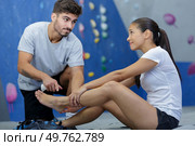 man helping woman who fell of a climbing wall. Стоковое фото, агентство Ingram Publishing / Фотобанк Лори