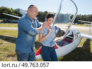 couple by glider man holding telephone to wifes ear. Стоковое фото, агентство Ingram Publishing / Фотобанк Лори