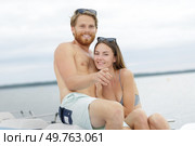 portrait of young couple wearing swimwear on pedalo. Стоковое фото, агентство Ingram Publishing / Фотобанк Лори