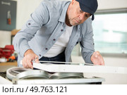 senior man working on an appliance in the workshop. Стоковое фото, агентство Ingram Publishing / Фотобанк Лори