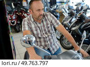 motorcyclist sitting on the motorbike in the store. Стоковое фото, агентство Ingram Publishing / Фотобанк Лори